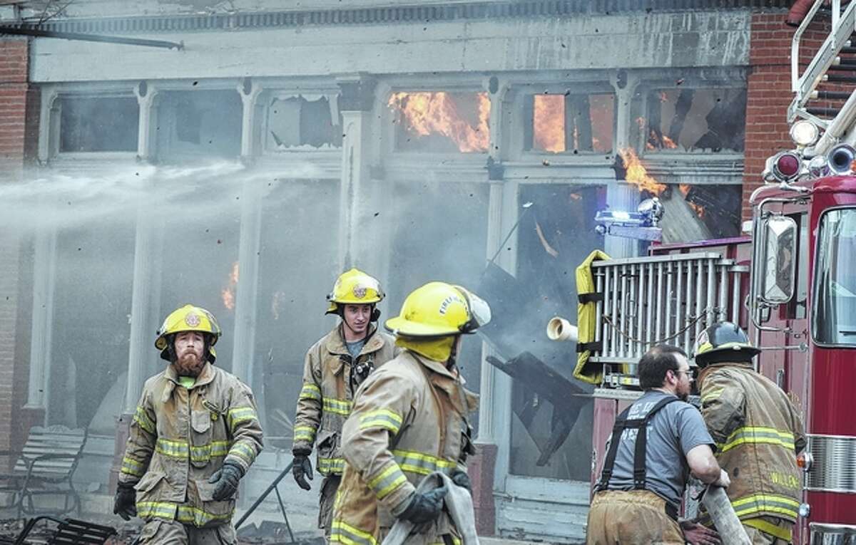Firefighters from eight departments battle a blaze that destroyed three buildings Tuesday in White Hall. The fire began in a residential building and spread quickly to neighboring buildings.