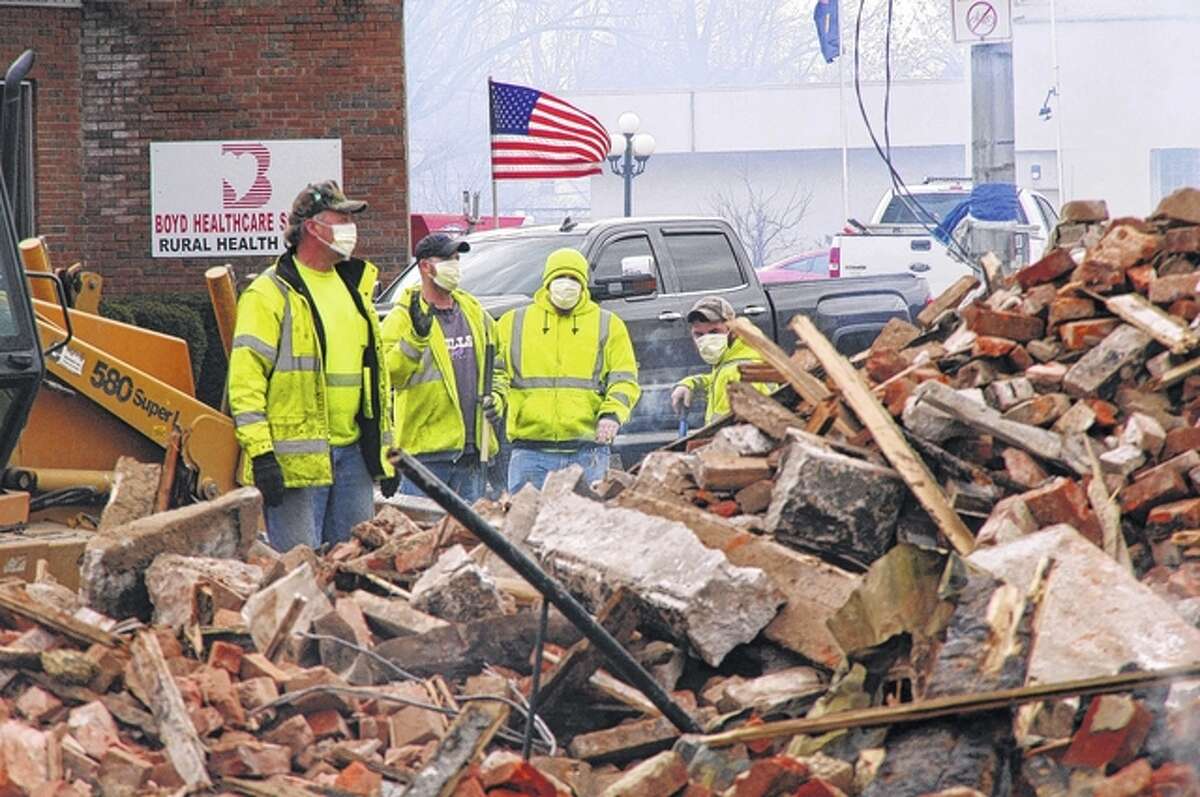 City crews survey a debris pile from Tuesday’s downtown White Hall fire.