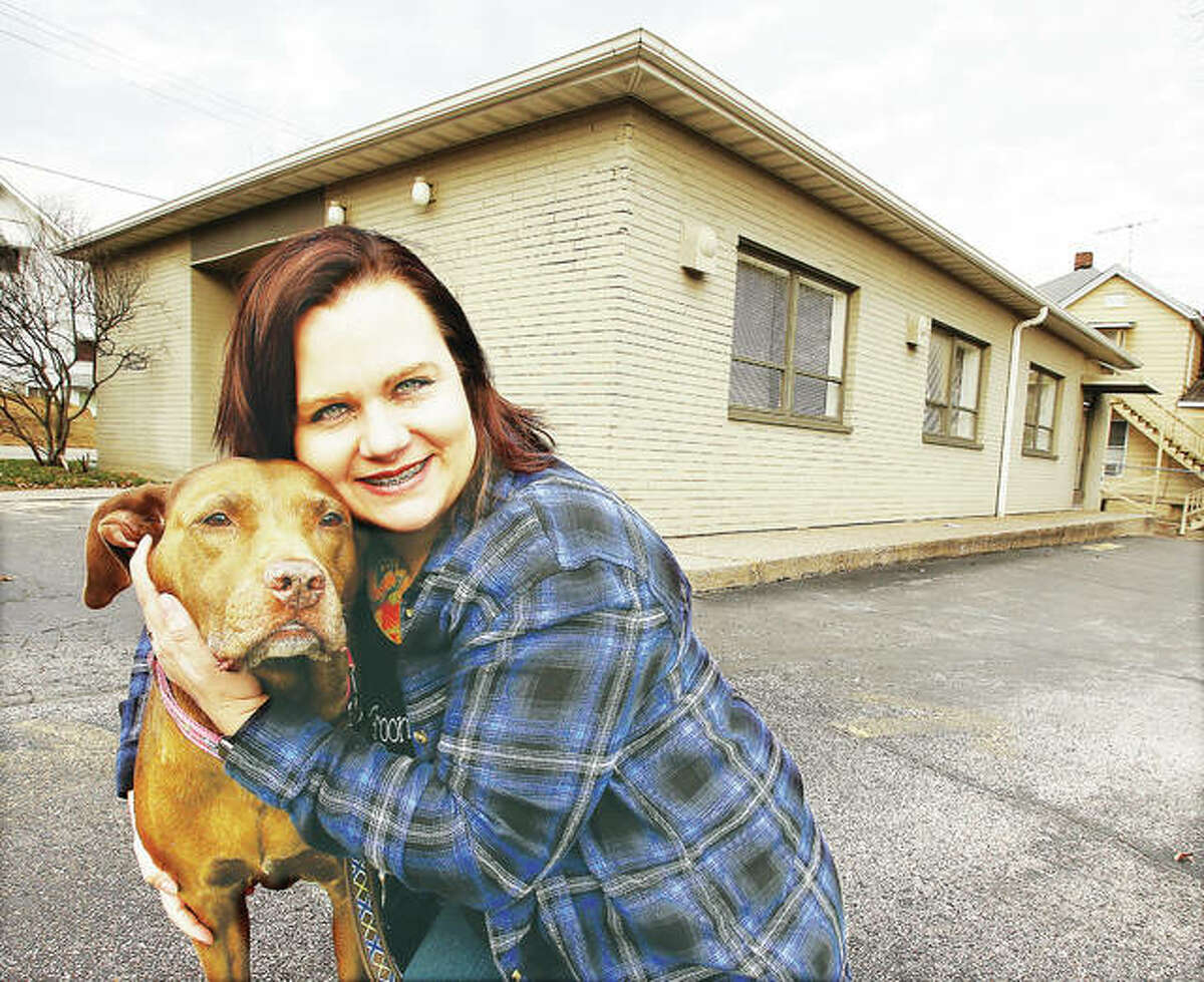 Alicia Jeffreys, owner of the Sham Pooches Grooming animal spa, with one of her canine friends in front of her business’ new location at 1735 Main St. in Alton.