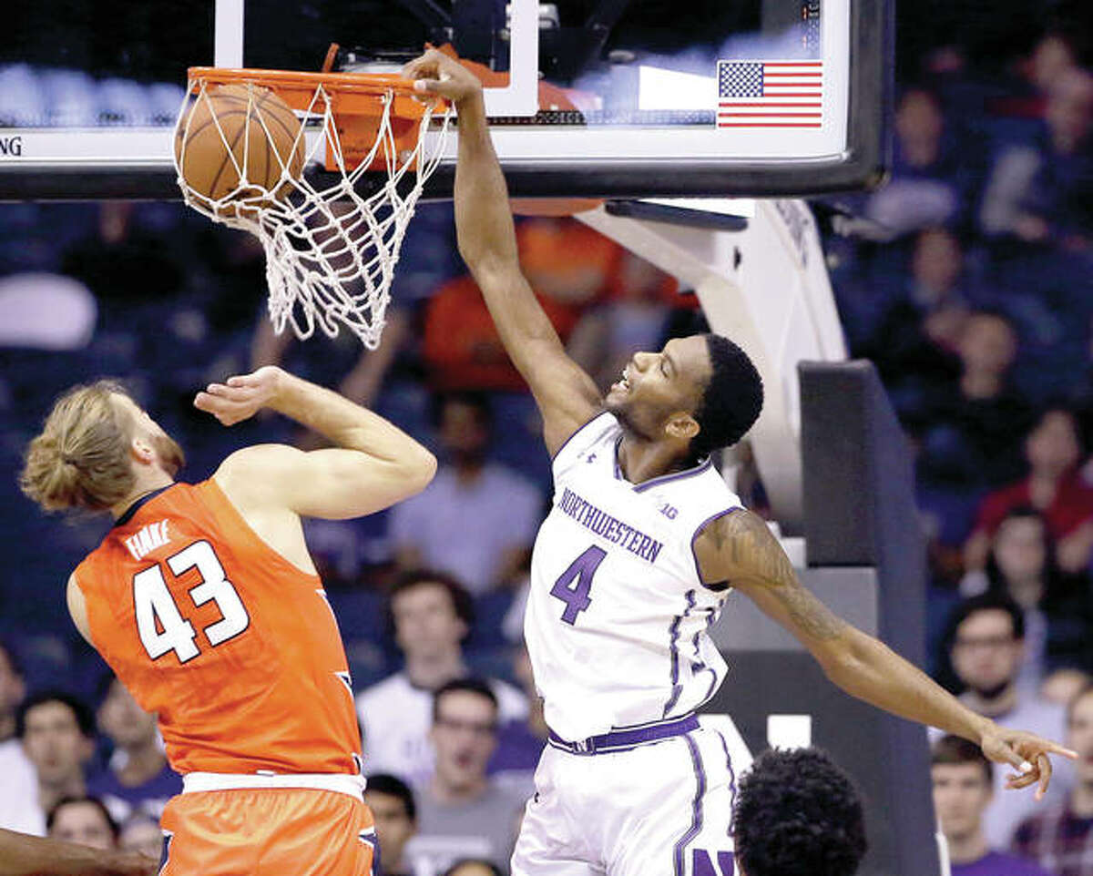 Northwestern forward Vic Law, right, dunks against Illinois forward Michael Finke during the first half of Friday’s game in Rosemont. Northwestern outlasted Illinois in overtime.