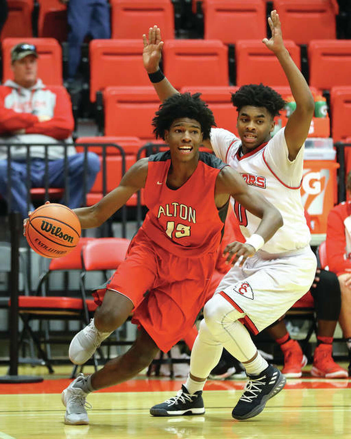 Alton’s Malik Smith (left) drives the baseline after getting past Granite City’s Jerry Watson during Saturday’s game at SIUE’s Vadalabene Center.