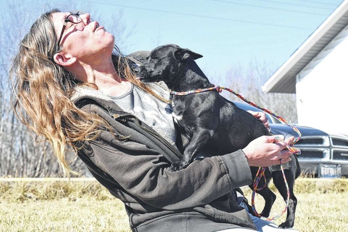 Kris Stocker, an employee at the Morgan County Animal Shelter, gives Chica, a young Chihuahua mix, a few pets during an afternoon stroll Friday. Chica will be up for adoption Feb. 21, assuming she is not claimed before then.