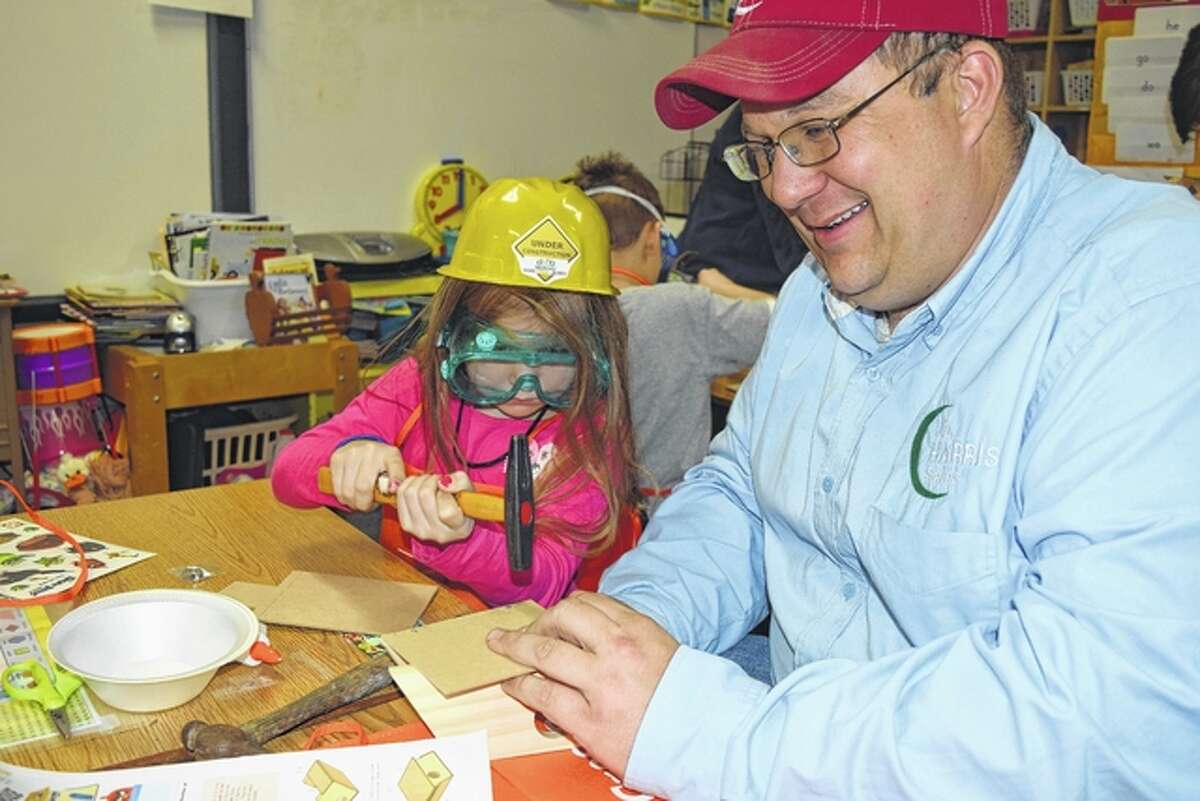 Claire Harris, the 5-year-old daughter of Jay and Mary Beth Harris of rural Jacksonville, helps her dad make a birdhouse Tuesday night at Salem Lutheran School, where she attends kindergarten.
