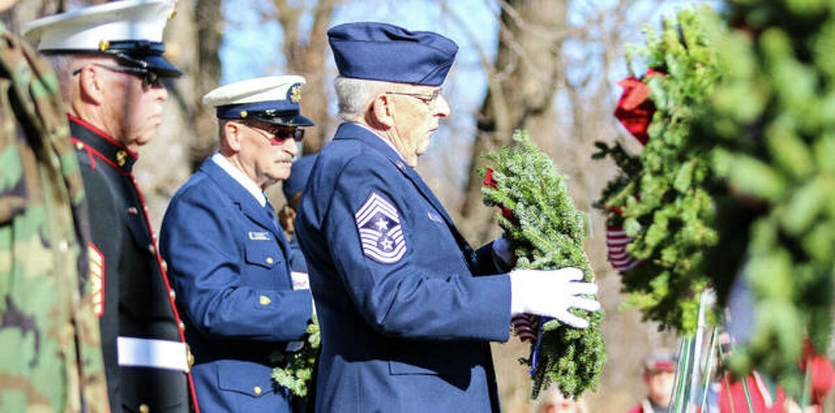 CCMS Bill Moyer, a United States Air Force veteran, places a wreath Saturday at Alton National Cemetery during the annual Wreaths Across America ceremony.