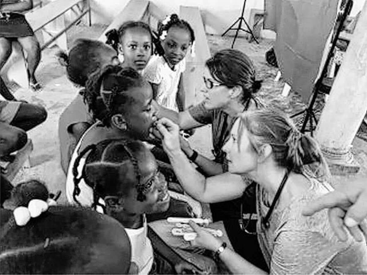 Valerie Griffin, DNP, assistant clinical professor in the SIUE School of Nursing, and nursing graduate student Lorilee Sebesta, apply fluoride to Haitian children’s teeth during their Oct. service trip.