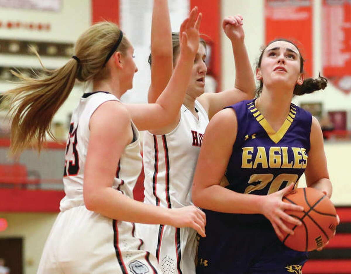 CM’s Anna Hall (right) drives through heavy traffic in the lane before shooting over Highland’s Mae Riffel and Lauren Baer (left) during Wednesday night’s Mississippi Valley Conference girls basketball game in Highland. Hall, a sophomore, scored a career-high 21 points in the Eagles’ 52-25 win.