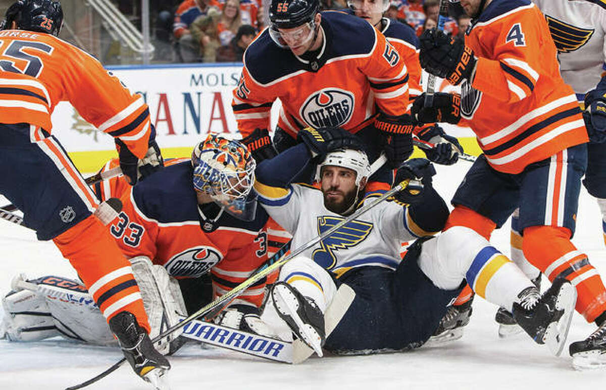 The Blues’ Chris Thorburn (middle) crashes into Oilers goalie Cam Talbot during the first period Thursday night in Edmonton, Alberta. The Oilers beat St. Louis 3-2.