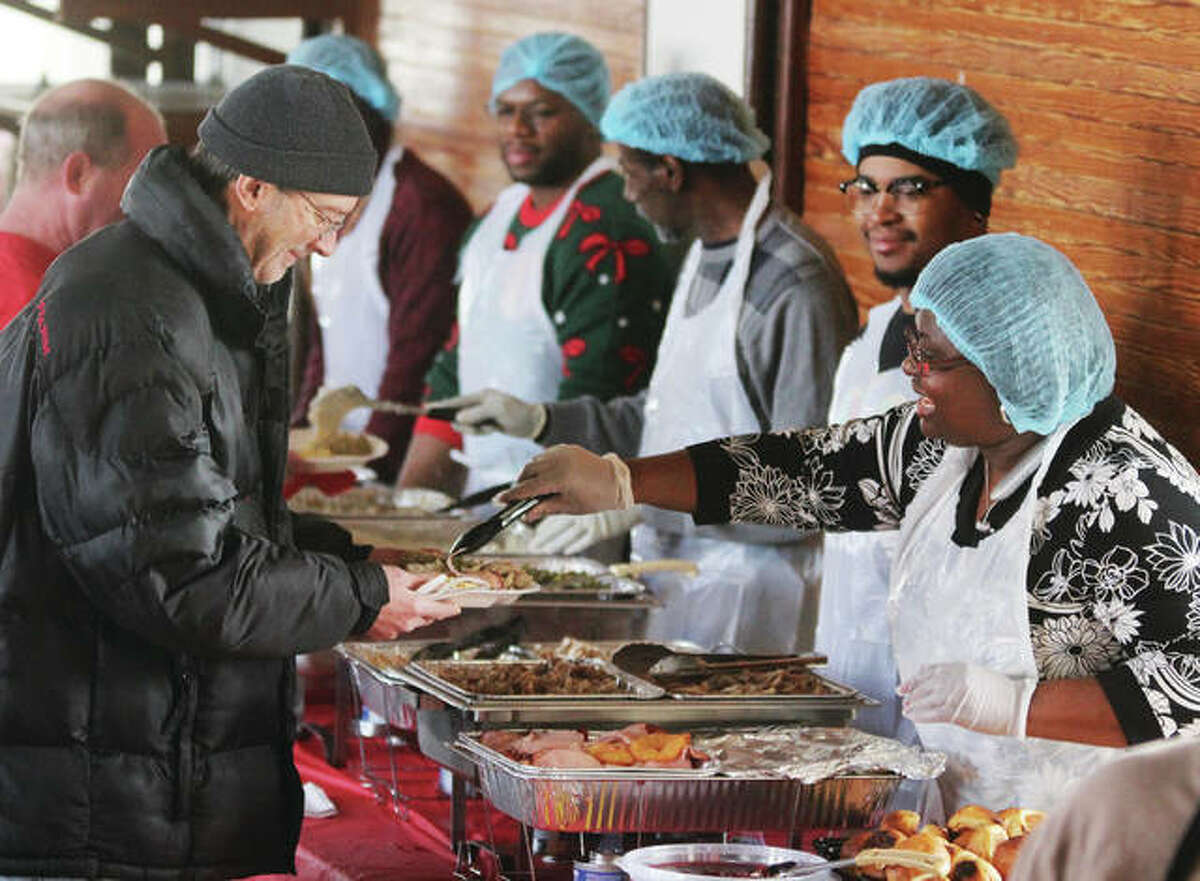 Members of St. John Missionary Baptist Church in Alton serve Christmas dinner. The church, located in the 400 block of Market Street, has been holding the dinner for about five years. Between 75-100 people normally come out to eat.