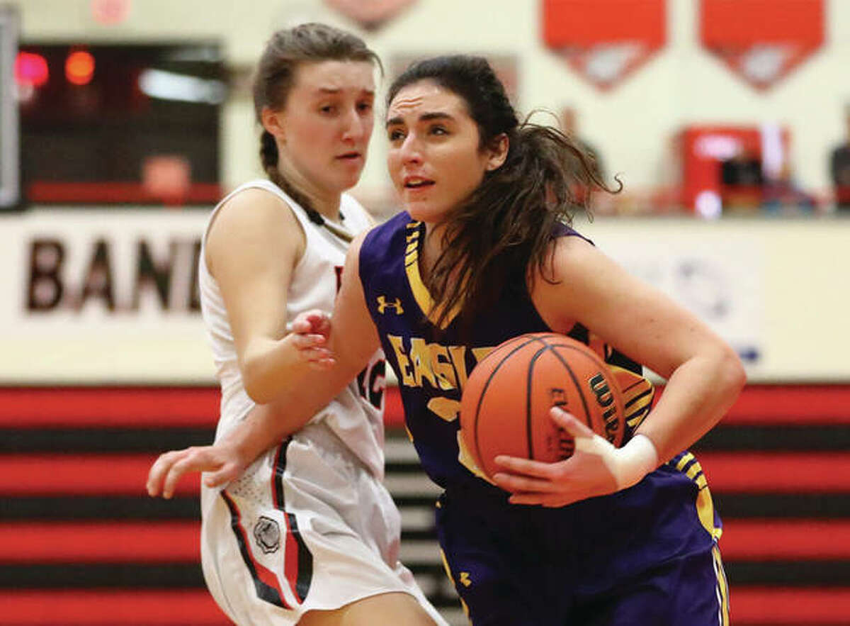CM’s Kaylee Eaton (right), shown driving past Highland’s Mae Riffel in a Dec. 20 game at Highland, and her Eagles teammates were back on the road Wednesday to open tourney play in Jerseyville.
