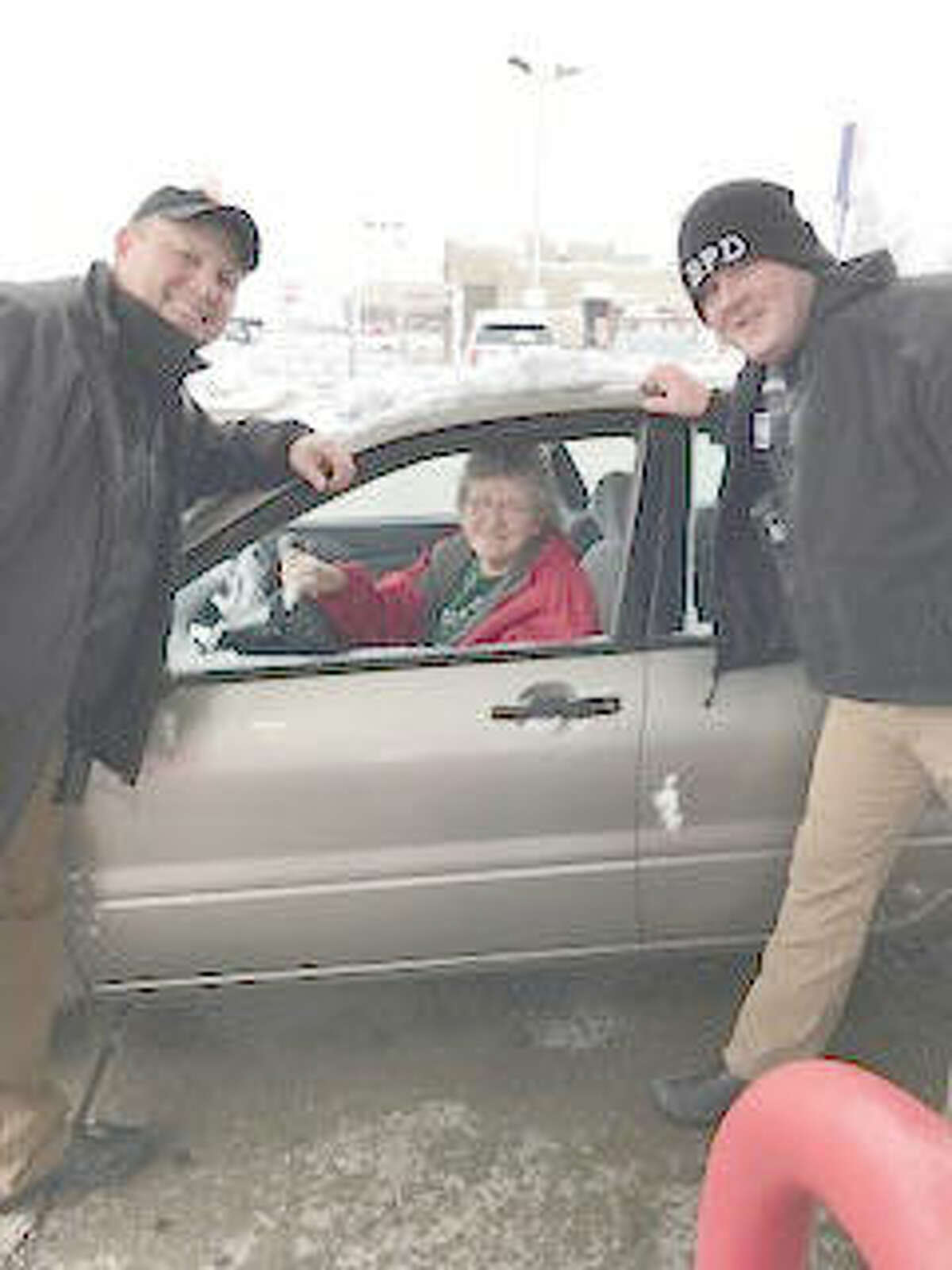 Bethalto Police Chief Greg Smock, left, and another BPD officer pose with a happy recipient of $20 in free gasoline Dec. 23 at the Hit-N-Run in Bethalto, compliments of Mustache March 4PD.