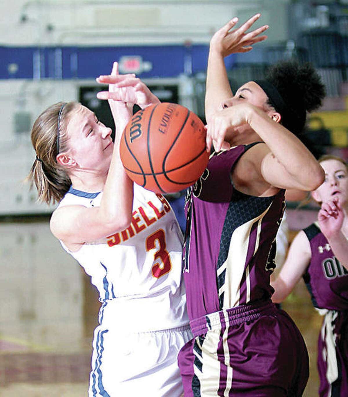 Roxana’s Emma Lucas, left, gets tangled up with EA-WR’s Kate Baskin while going up for a shot Wednesday night in Roxana.
