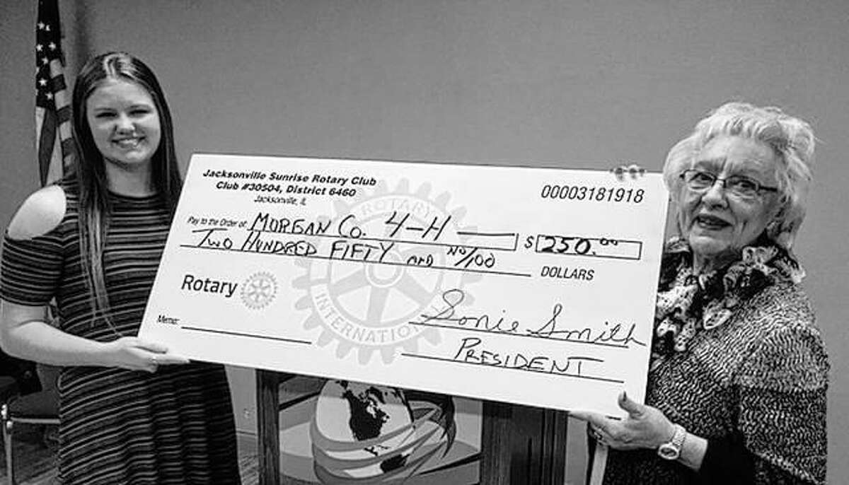 Anne Becker, a local 4-H club member, receives a check from Sunrise Rotary Club President Sonie Smith representing a $250 contribution. Ms. Becker is working with 4-H clubs from several west central Illinois counties to package food items for local food banks. The funds are part of the proceeds from hole sponsorships from Sunrise Rotary’s annual golf outing.