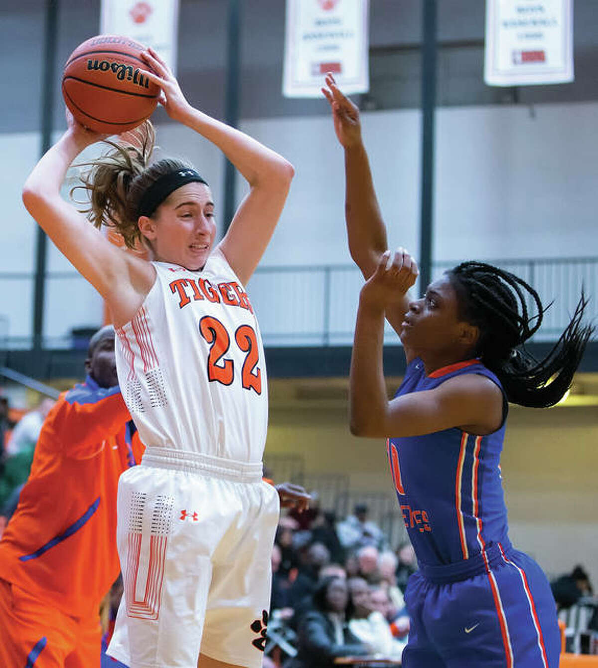 Edwardsville’s Kate Martin (left) looks inside for a teammate over East St. Louis’ Rokelle Stanley during a Tigers’ victory Dec. 20 in Edwardsville. The 16-0 Tigers got by a challenging stretch of their schedule unscathed and are ranked No. 1 in the Class 4A state poll.