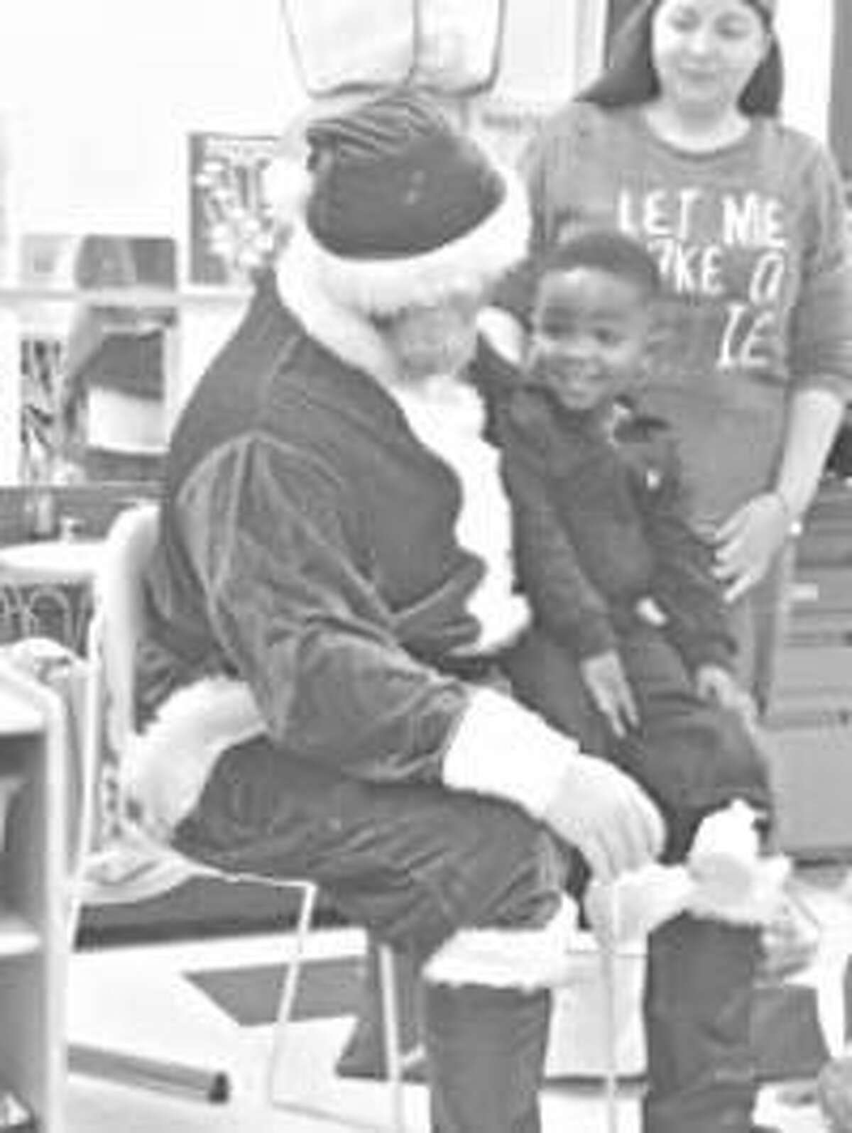 A Head Start participant sits on Santa’s lap during the SIUE School of Nursing WE CARE Clinic’s Christmas event Dec. 19.