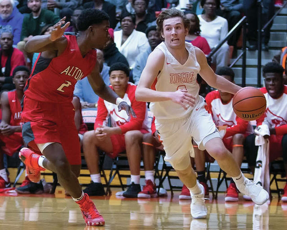 Edwardsville’s Jack Marinko (right) drive past Alton’s Kevin Caldwell Jr. during a Southwestern Conference boys basketball game Friday night a Lucco-Jackson Gym in Edwardsville. Marinko led all scorers with 33 points, but Caldwell’s 15 led the Redbirds to an overtime victory.