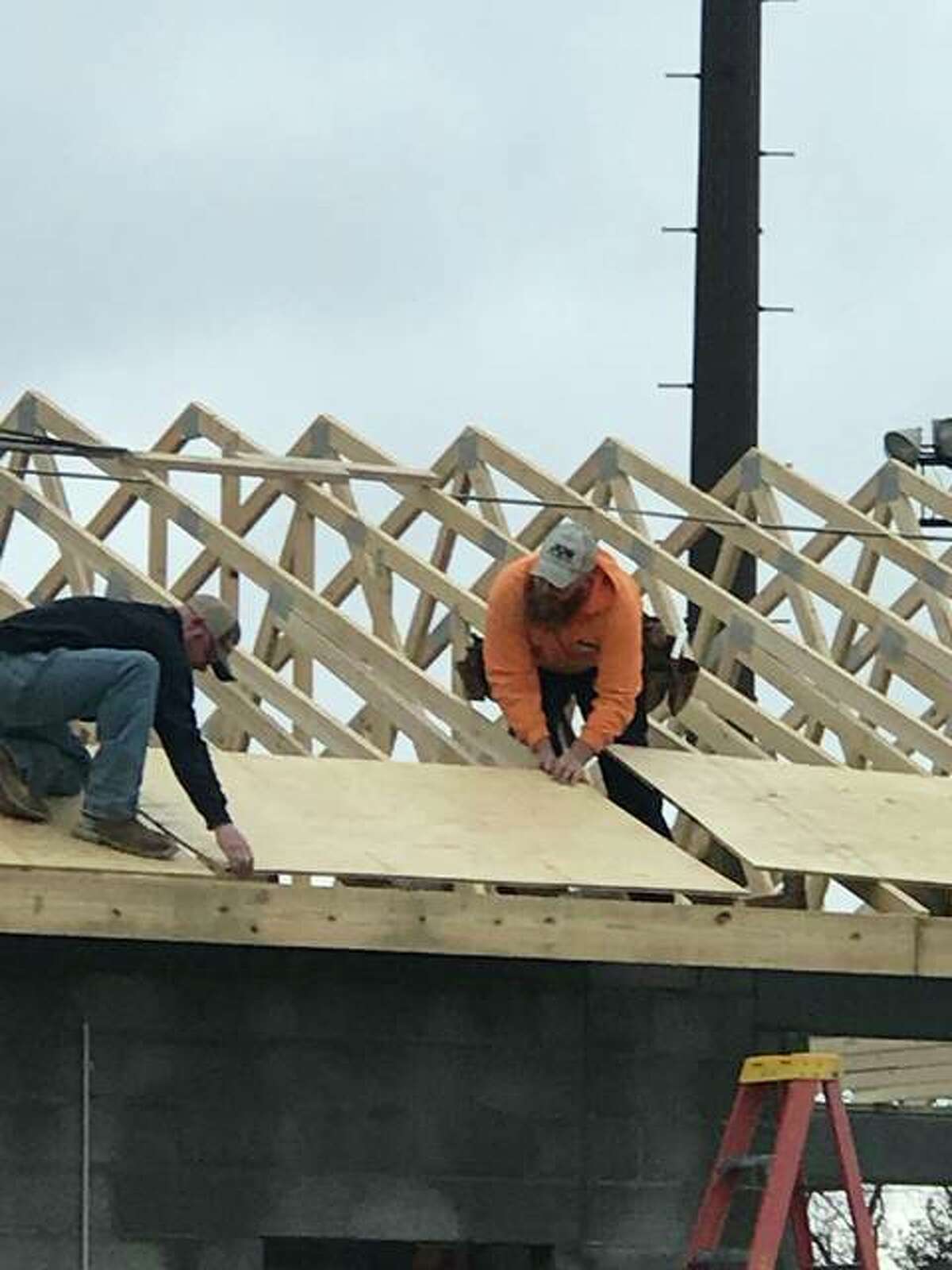 Volunteers from Jun Construction of Godfrey put up roof trusses and sheeting on the evolving concession and restroom building at Gordon F. Moore Park on Wednesday, Jan. 10. The $300,000 structure is one of 12 of the most significant projects for which the city issued a building permit in 2017.
