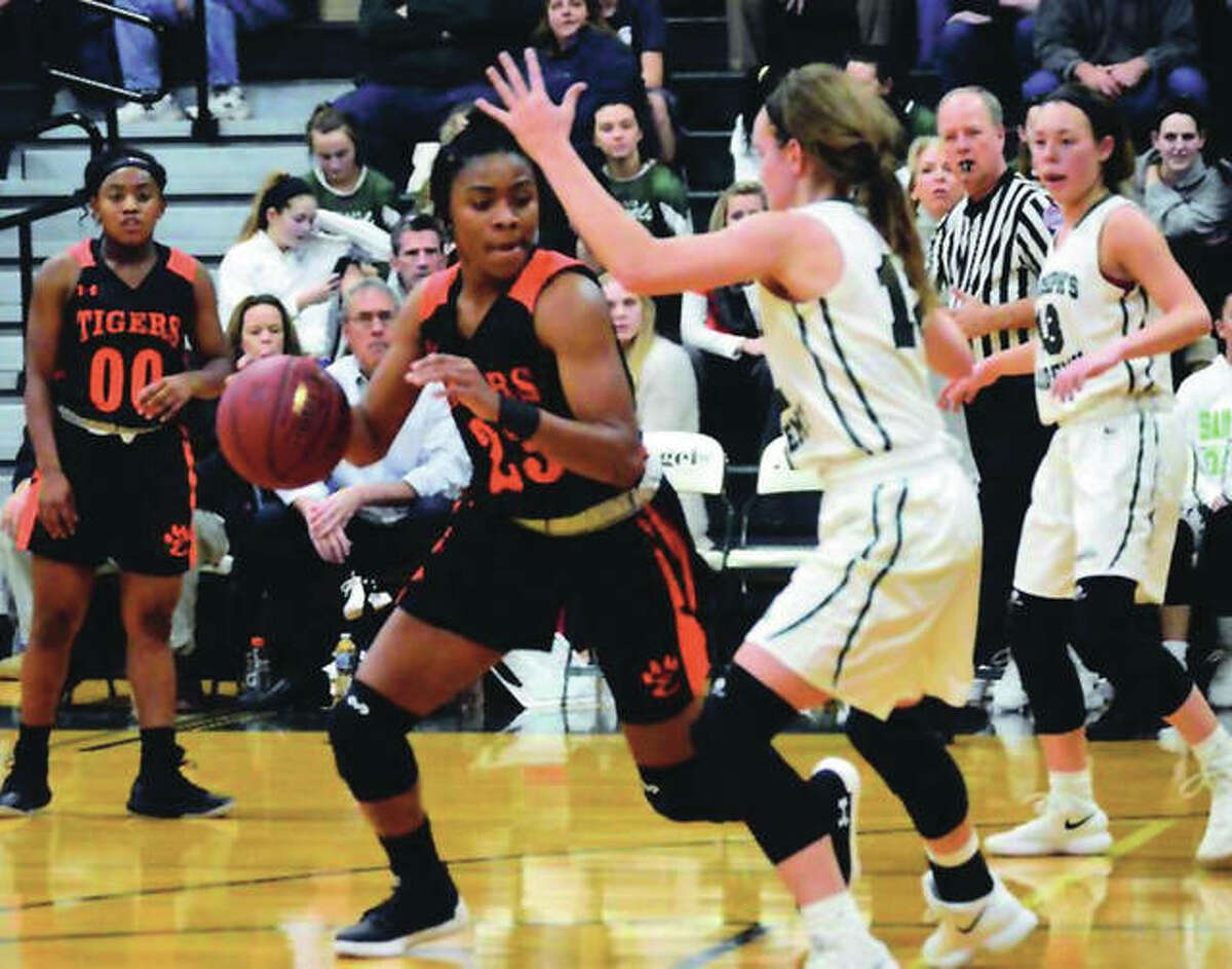 Edwardsville’s Myriah Noodel-Haywood handles the ball against defensive pressure from St. Joseph’s Academy’s Mary LaBelle during a nonconference girls basketball game Wednesday night in St. Louis. The Tigers won to improve to 19-0.