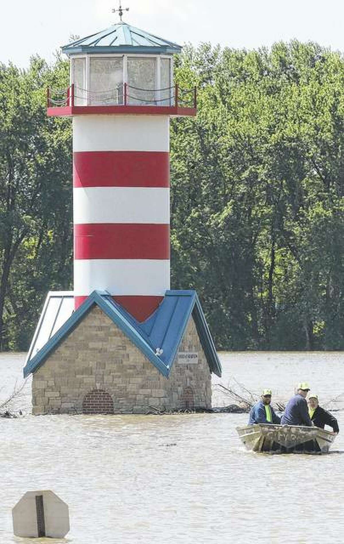Workers from the Grafton Public Works Department travel by boat back to land after moving logs on the riverfront. Flood warnings remain for large sections of west-central and southern Illinois after weekend storms brought several inches of rain and more rain Wednesday keep waters from receding.