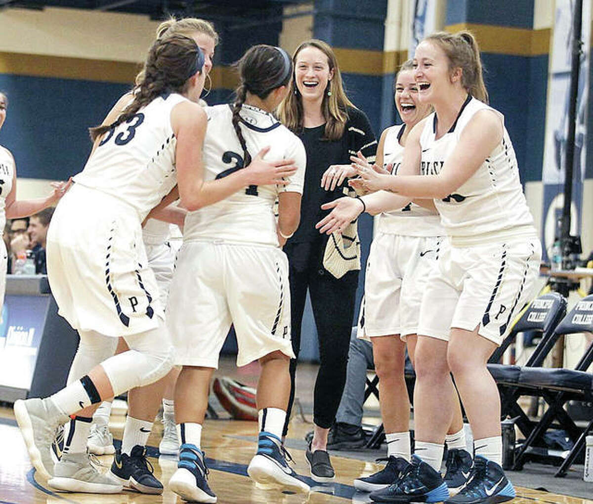 Members of the Principia College junior varsity women’s basketball team celenrate during a recent game. Prin has announced that it will bring back varsity women’s basketball next season following a two-season absence.