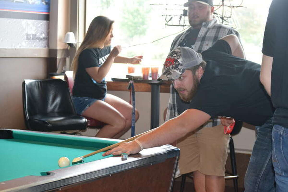 Illinois College student Fischer Tharp aims for the winning shot in his pool game Thursday at On The Rox in Jacksonville.