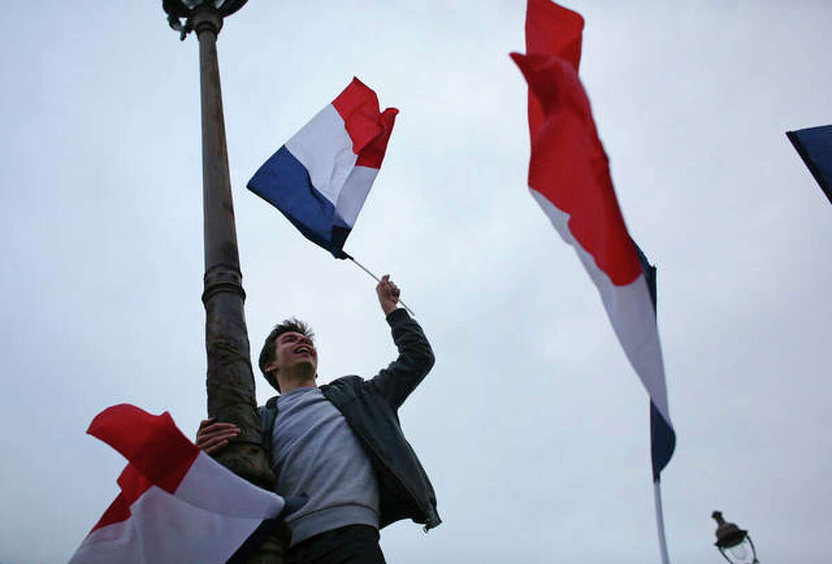 Thibault Camus | AP A supporter of French independent centrist presidential candidate Emmanuel Macron celebrates outside the Louvre museum in Paris, France.