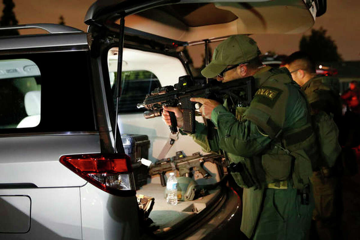 Jae C. Hong | AP An ATF agent checks his weapon as he gets ready for a raid May 17 in Los Angeles. Hundreds of law enforcement fanned out across Los Angeles, serving arrest and search warrants as part of a three-year investigation into the violent and brutal street gang MS-13.