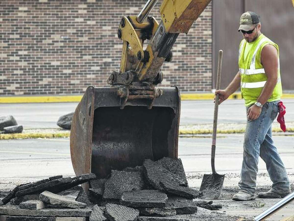 Brad Ford of Versailles, an employee of United Contractors Midwest, watches as the approach to Morton Avenue from the Lincoln Square Shopping Center is broken up Wednesday in preparation for a phase of an ongoing road project.