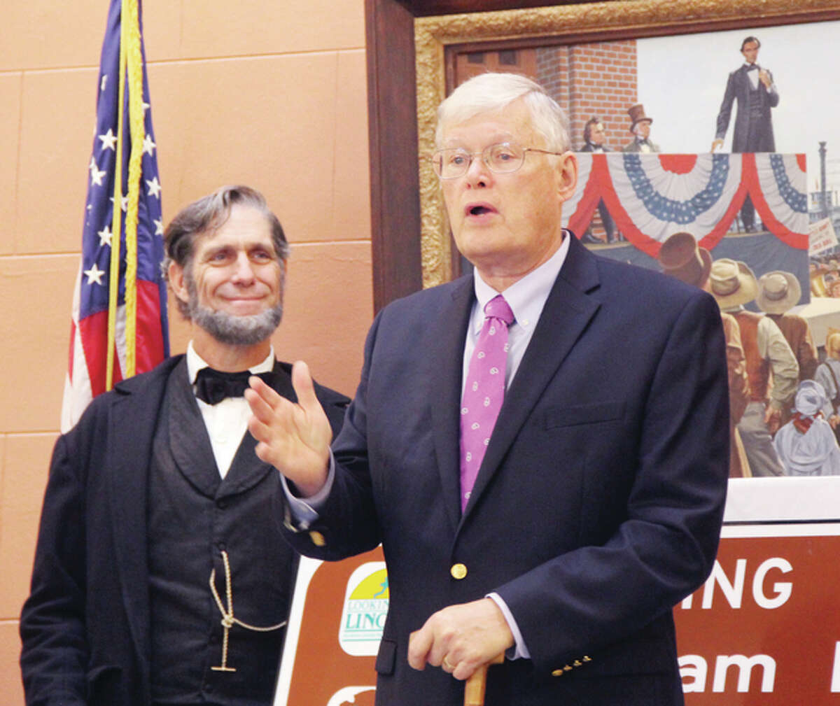 State Sen. Bill Haine (D-Alton) talks about the history of Abraham Lincoln and the abolitionist movement in Alton Wednesday morning as Lincoln impersonator Randy Duncan, of Carlinville looks on. Behind them is a painting showing a younger Lincoln at the Lincoln-Douglas Debate in Alton. Official were at City Hall Wednesday to announce the inclusion of Alton as one of six Gateway Cities to the Abraham Lincoln National Heritage Area in Illinois.