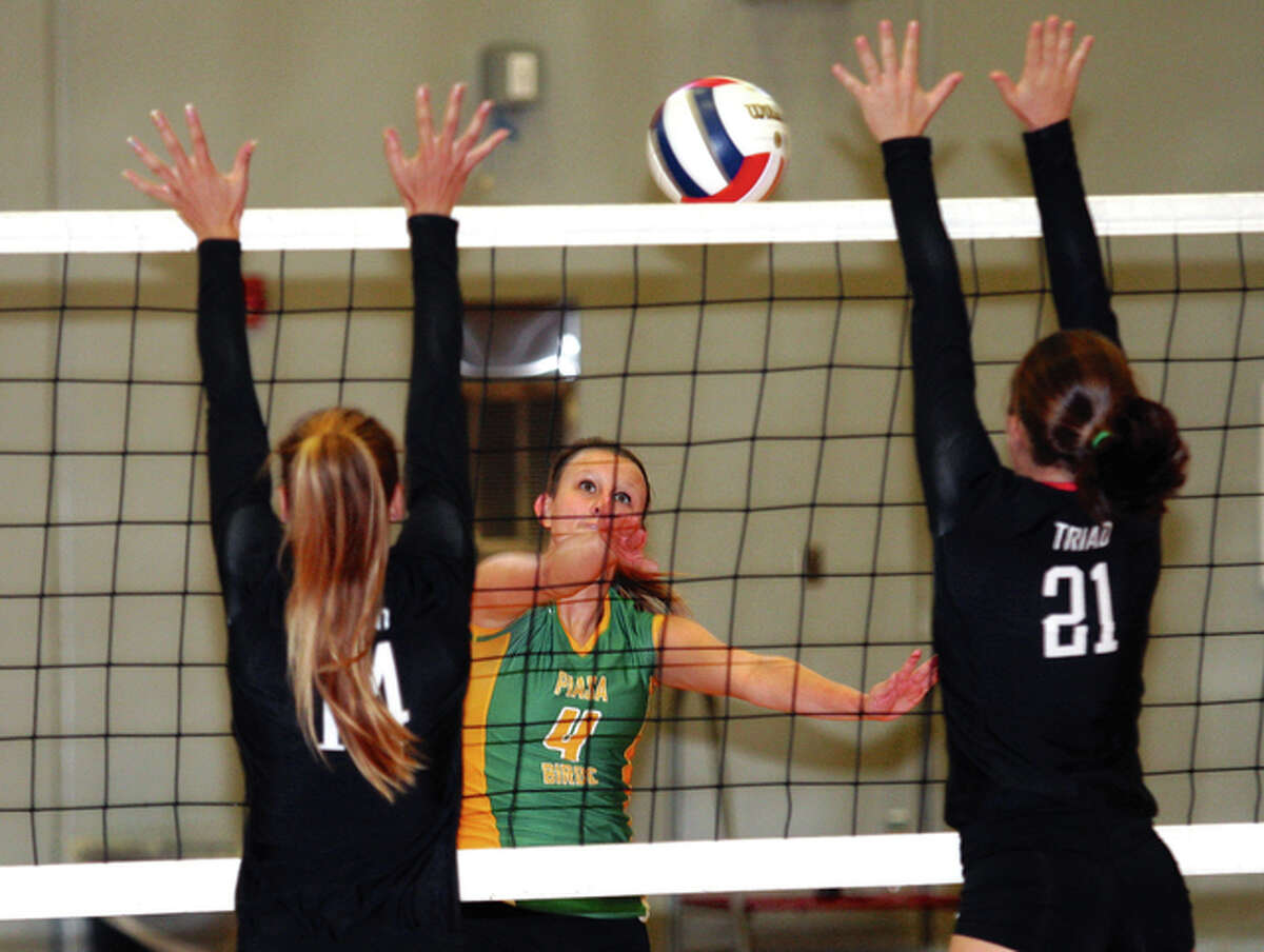 Southwestern’s Jenna Moore (middle), shown in a match last season sending the ball through the block put up by Triad’s Abby Richter (left) and Hannah Johnson, and the Piasa Birds fell to the Gillespie Miners in a South Central Conference match Thursday in Piasa.