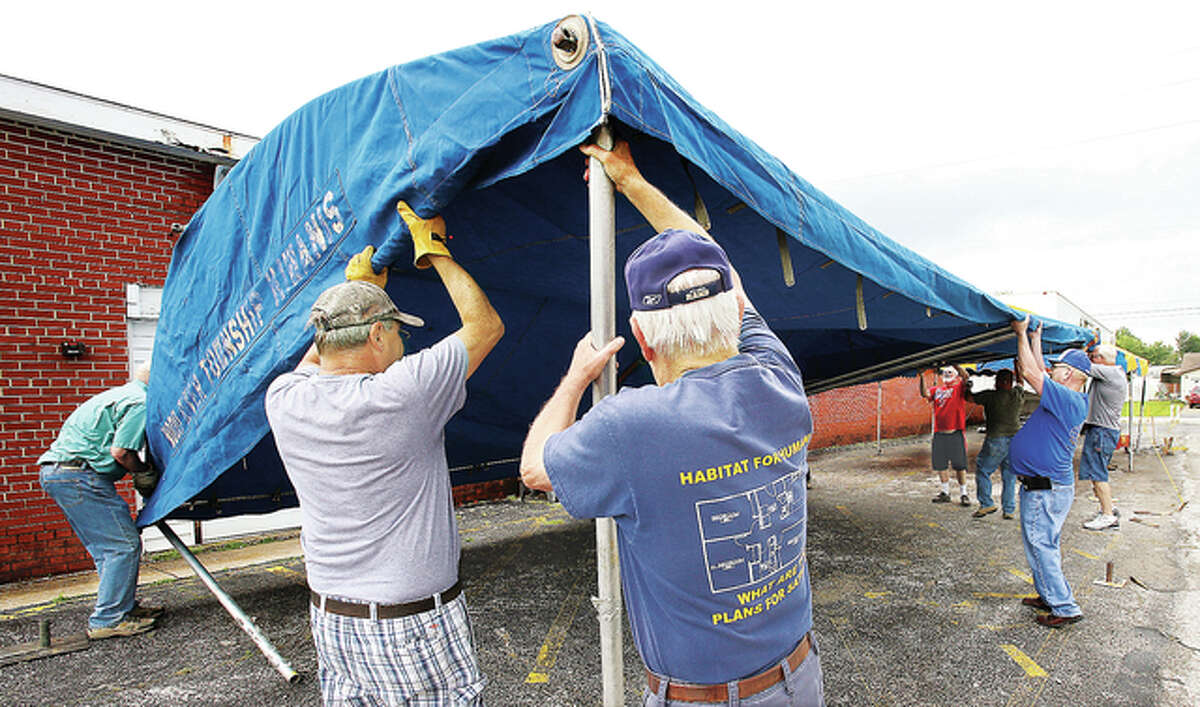 Members of the Kiwanis Club of Wood River Township set up one of their tents for their barbecue on the lot of the former Hutton Ford body shop on Illinois Route 111 in Wood River.