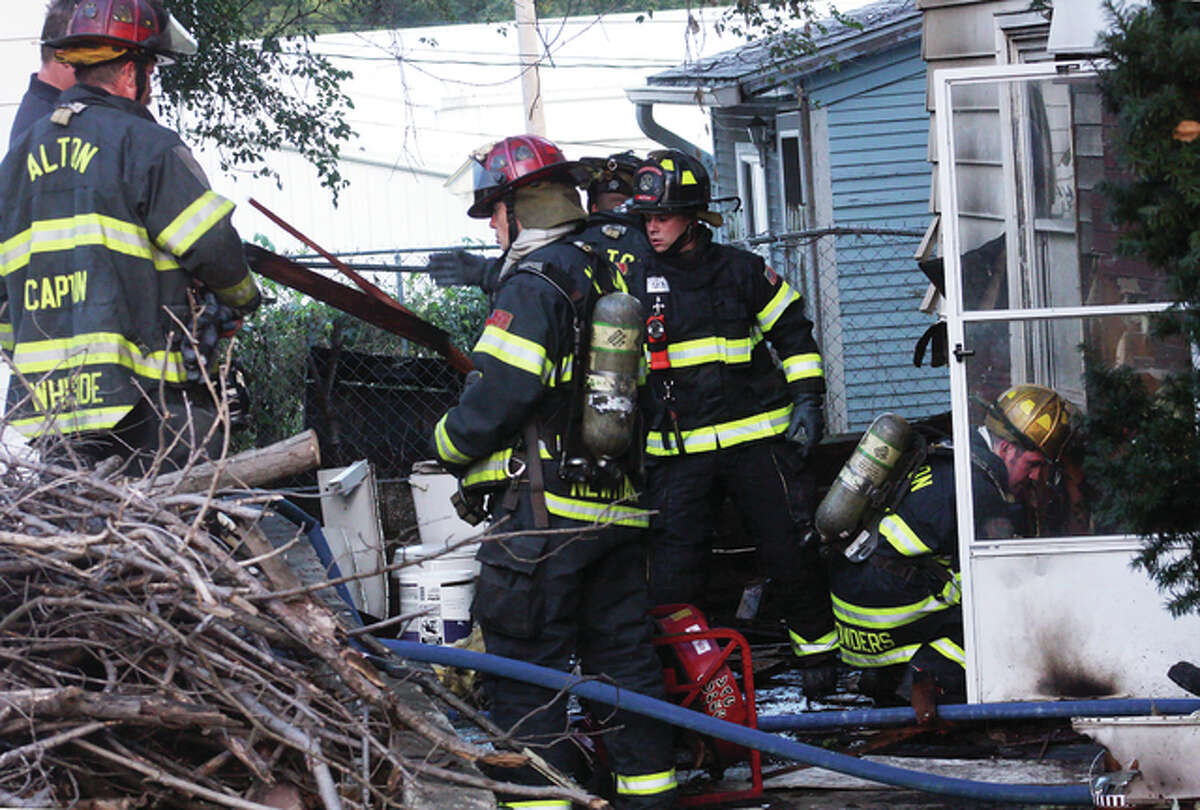 Alton and East Alton firefighters process the scene of a suspicious fire Sunday evening at 2814 E. Broadway.