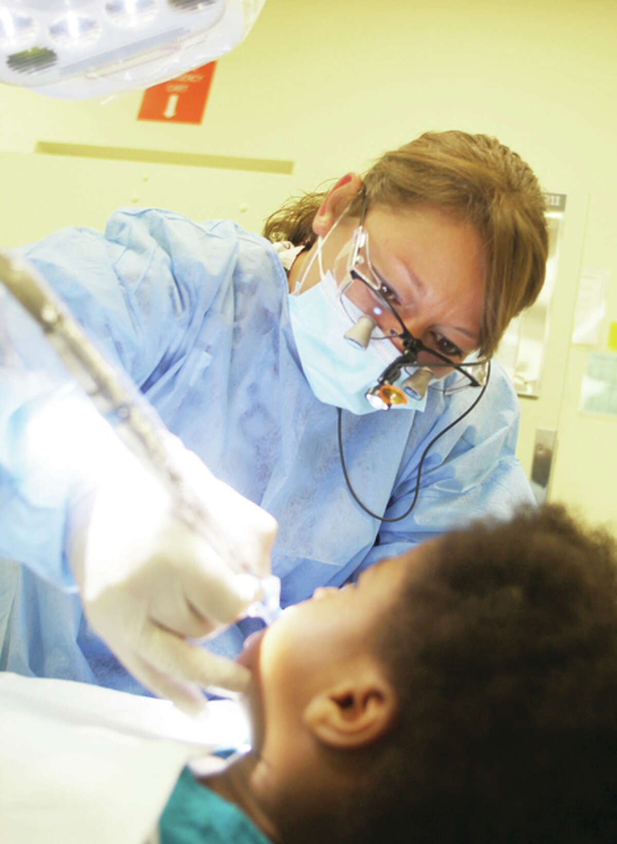 Lewis and Clark Community College dental hygiene student Dawn Green, of Alhambra, cleans the teeth of Ramone Cunningham, 3, of Cottage Hills, Monday at the annual Give Kids a Smile Day at the Southern Illinois University School of Dental Medicine.