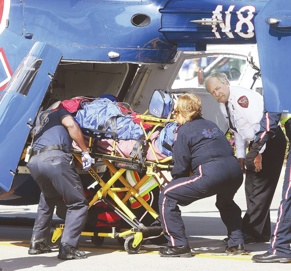 ARCH Air Medical Services Inc. flight nurses and Alton Battalion Chief Brad Sweetman, right, load the forklift driver into the helicopter for an airlift to St. Louis.