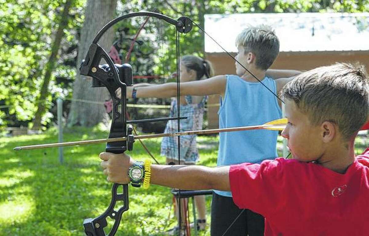 Eli Blankenship, 8, of Jacksonville (foreground), Gavin Little, 9, of Franklin and Lola Rowe, 9, of Jacksonville hone their archery skills Wednesday at Western Illinois Youth Camp’s summer camp. The nine-week camp ends Aug. 11.