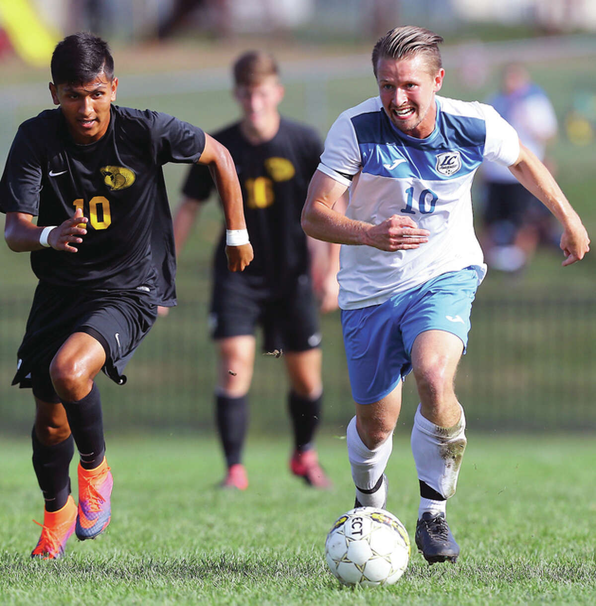 Lewis & Clark’s Lochlan Reus, right, drives the ball upfield as he is trailed by Parkland’s Alex Zarco during Saturday’s match at LCCC’s Soccer Stadium in Godfrey.