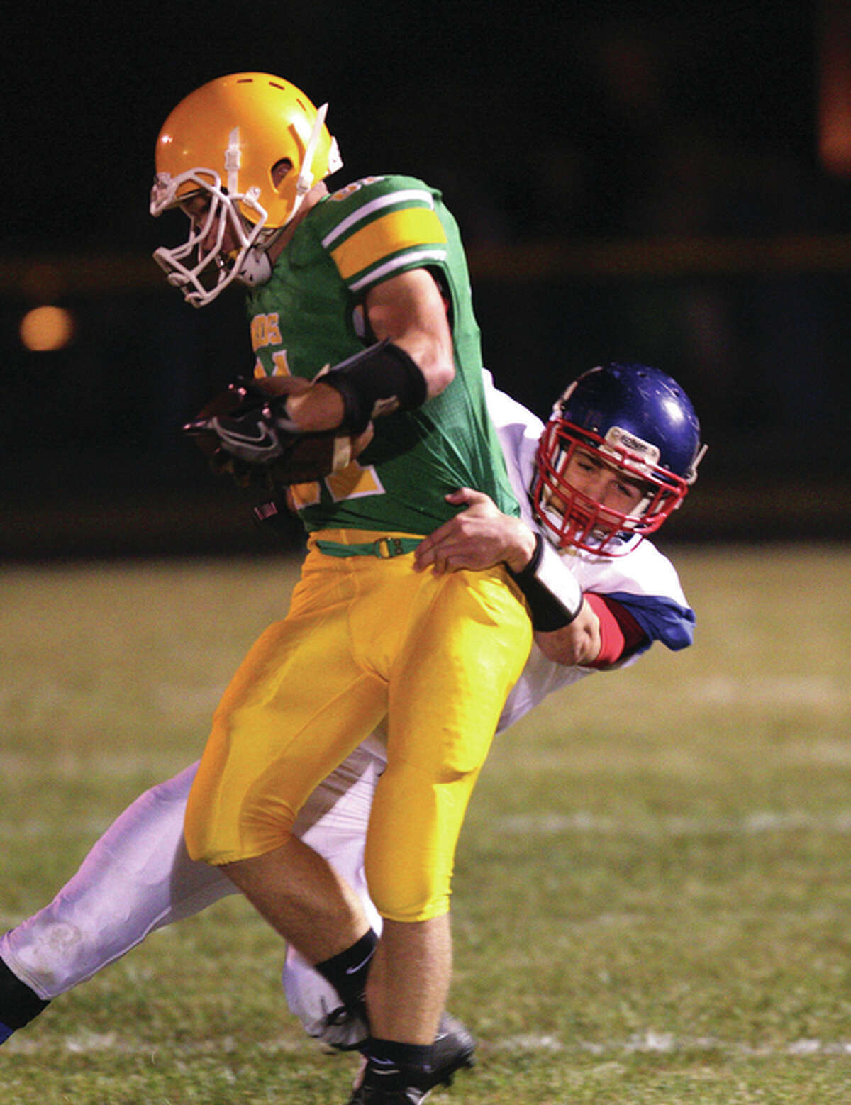 After pulling in a pass, Southwestern’s Michael Nolte (front) gets pulled down by Carlinville’s Jacob Dixon during the first half of last Friday night’s South Central Conference game at Knapp Field in Piasa. The Piasa Birds play at Roxana, while Carlinville plays host to Litchfield on Friday.