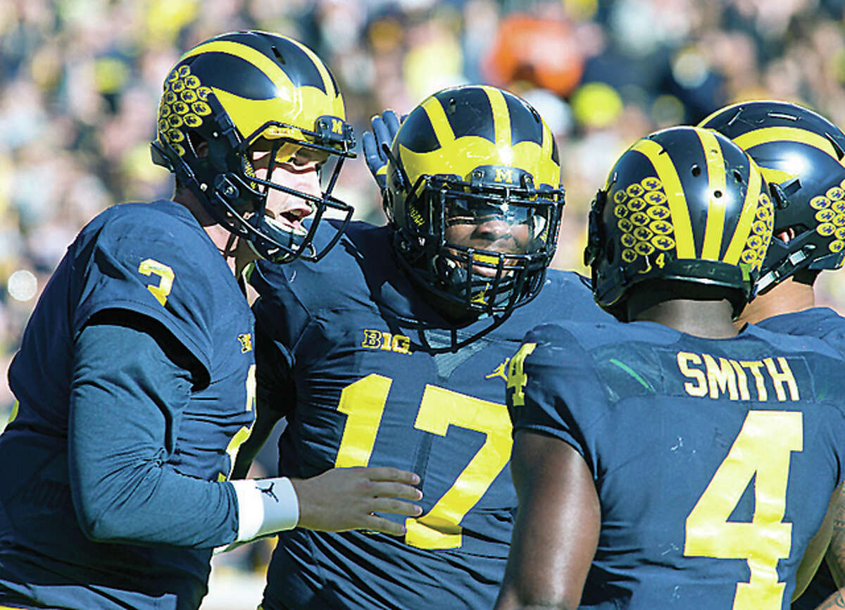 Michigan quarterback Wilton Speight, left, celebrates a touchdown against Illinois with tight end Tyrone Wheatley (17) and running back De’Veon Smith (4) in the first quarter Saturday in Ann Arbor, Michigan