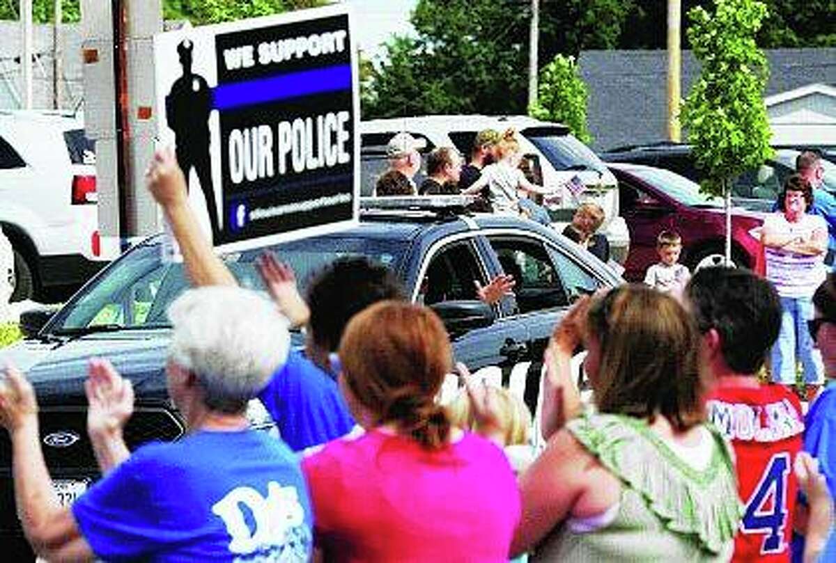 A convoy escorts a Jerseyville police officer injured last week in a deadly shootout home from the hospital. Hundreds gathered with signs of support and applause for the homecoming of Officer Nathan Miller, 30, who was struck multiple times by gunfire.