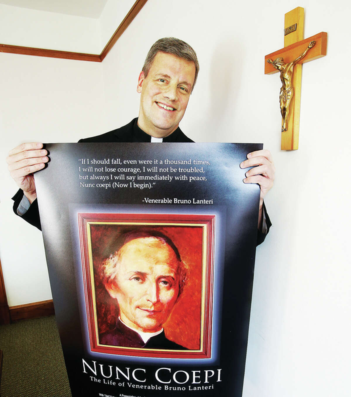 Fr. John Wykes, from St. Mary’s Catholic Church in Alton, holds a promotional poster for the film he co-produced and directed on Bruno Lanteri, the founder of his order, Oblates of the Virgin Mary. The film will be previewed in Italy, Boston and Alton.