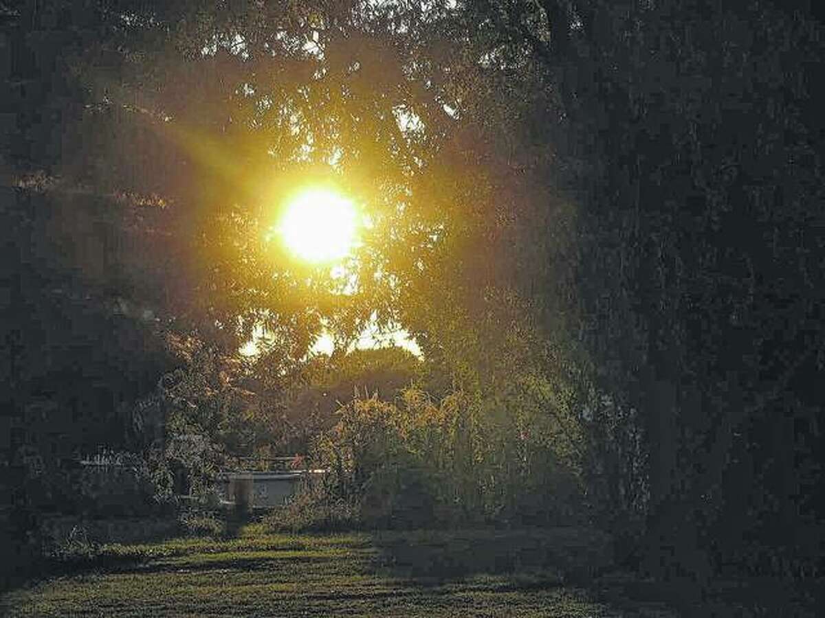 The setting sun appears to create a path across a yard in Scottville.