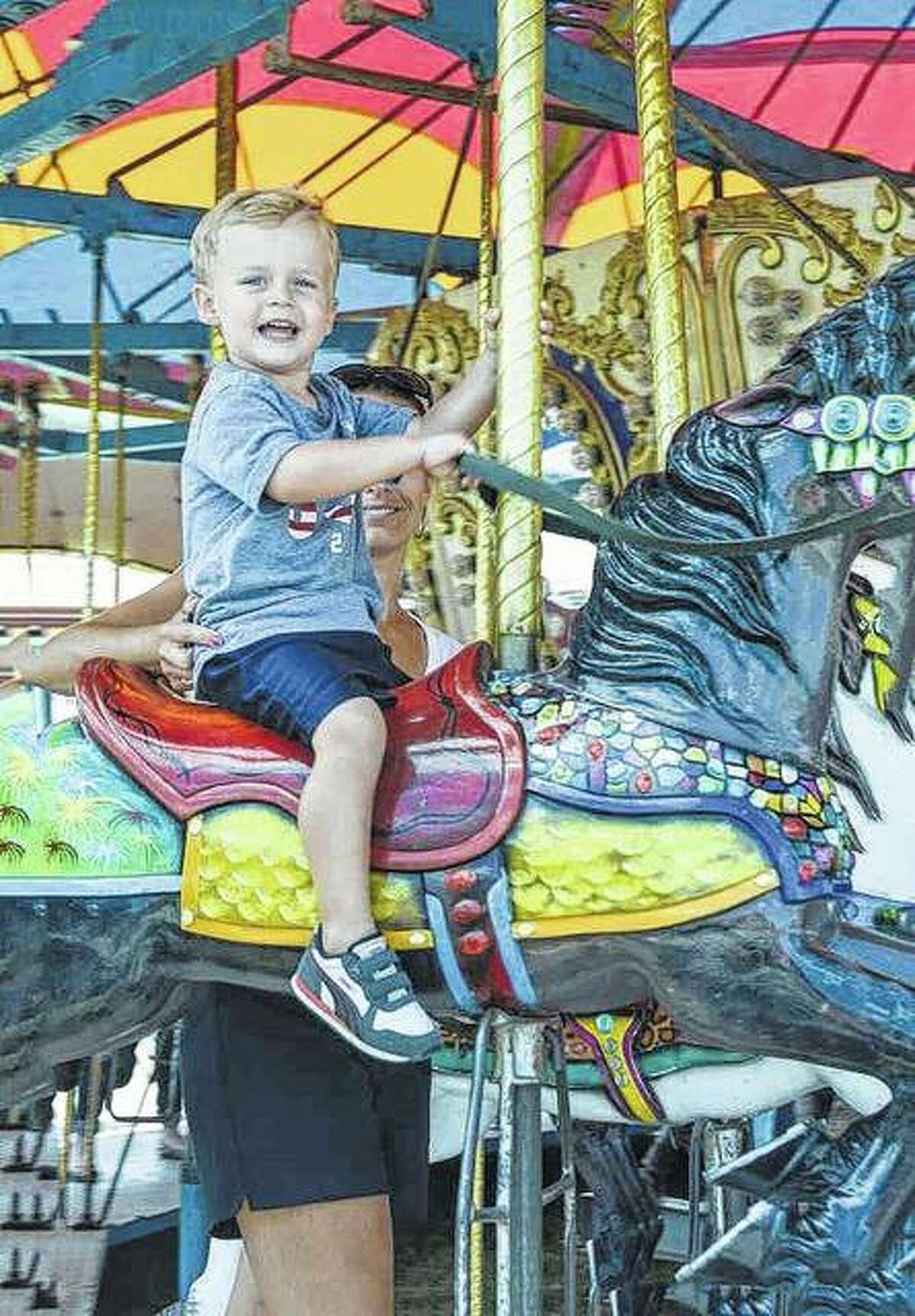 FILE - Ryker Foster of Jacksonville enjoys a ride on the carousel at the Illinois State Fair in Springfield.