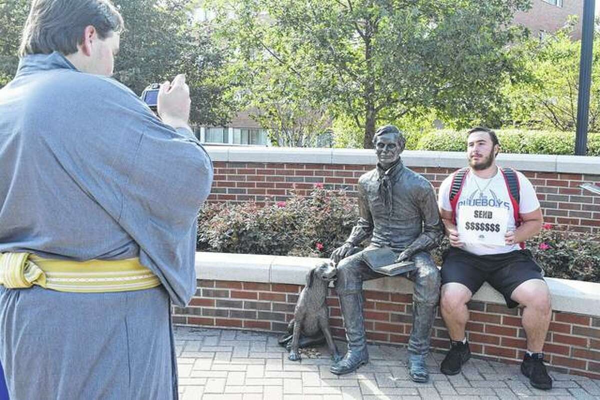Illinois College junior Joshua Condon takes a picture of freshman David Dellit alongside an Abraham Lincoln statue in the Steuer Walkway on campus Tuesday. It has become a tradition for students at the college to take their picture with the president during the first full day of classes.
