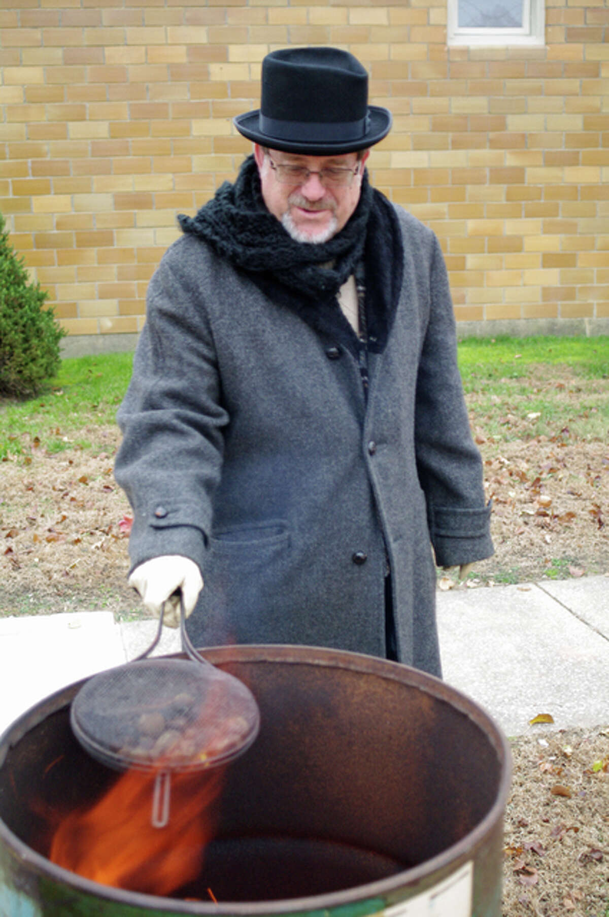 Rev. Willy Meyer roasts chestnuts over an open fire on behalf of the Kiwanis Club during Sunday’s 26th annual Christmas Walk in Downtown Bethalto.