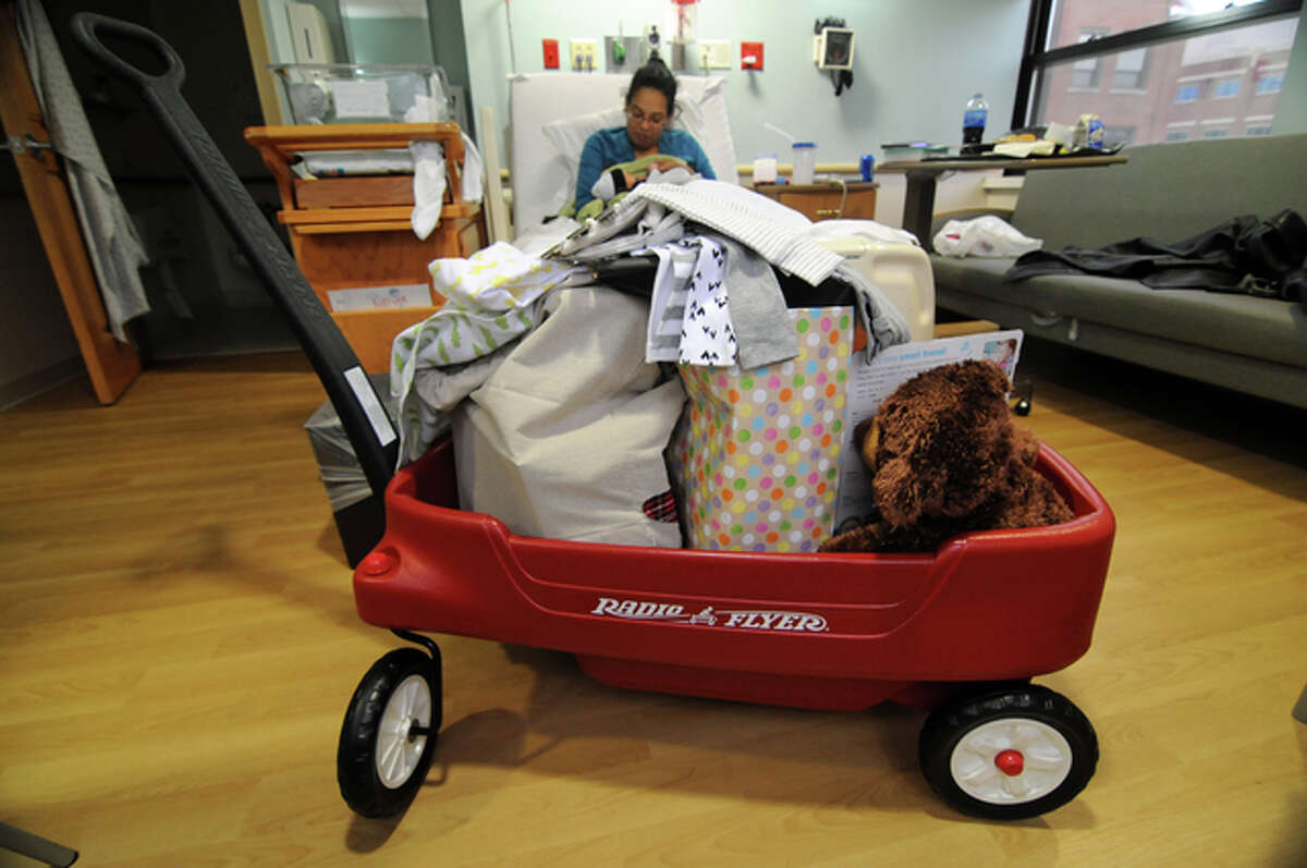 The wagon full of goodies reserved for the New Year’s baby sits in Jackson Scott Daniels’ room at Alton Memorial Hospital, as Jackson and his mother, Elizabeth Daniels, snuggle in the background.