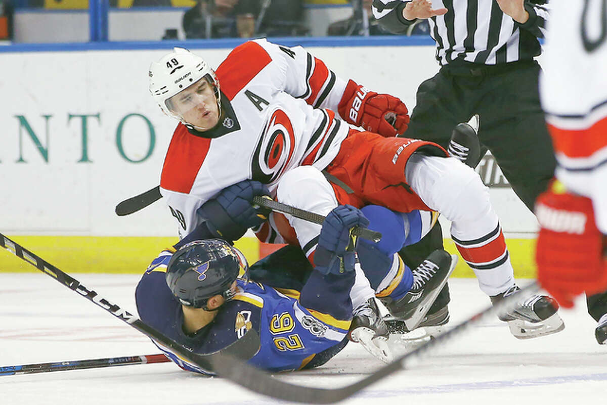 Carolina’s Victor Rask, top, levels the Blues’ Paul Stastny during the second period of Thursday’s game in St. Louis.