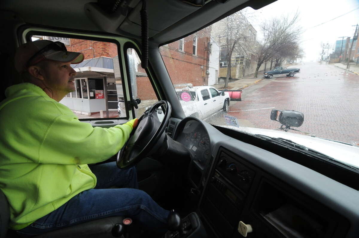 Public Works employee Paul Wallace maneuvers a salt-spreading dump truck on Alton’s steep brick streets on Sunday.