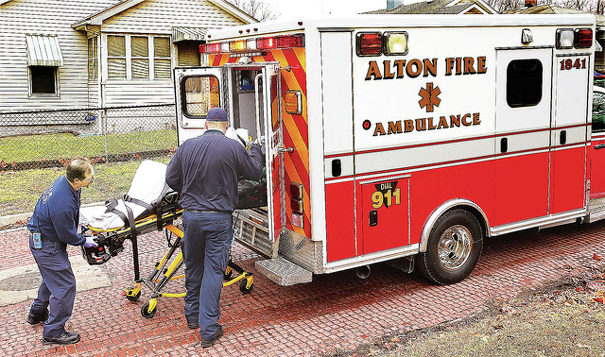 Alton Fire Department paramedics load a patient into the department’s ambulance Monday at an EMS call on Dorris Street in Alton. Monday was the first day of fire department-provided ambulance service in the city of Alton.