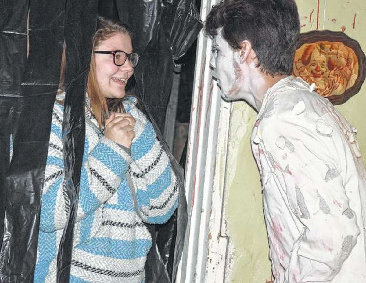 Paige Ehlenbeck of Winchester gets scared by Drake Gregory during the Winchester Civic Group haunted house Friday at the Winchester Old School Museum. The haunted house will continue from 5:30-10 p.m. A kid-friendly, lights-on family time and wiener roast will take place from 5:30-6:30 p.m. and is $10 per family. The haunted house will take place from 7-10 p.m. and is $5 per person.
