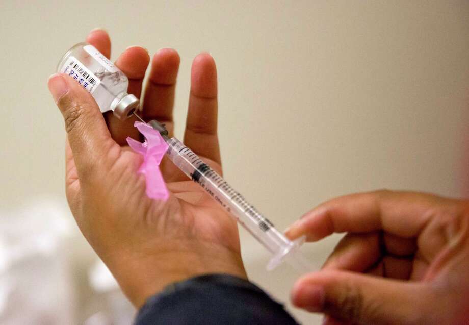 FILE - In this Wednesday, Feb. 7, 2018 file photo, a nurse prepares a flu shot at the Salvation Army in Atlanta. The U.S. government's Friday, Feb. 9, 2018 flu report showed the flu has further tightened its grip on the U.S. This season is now as intense as the swine flu epidemic nine years ago. (AP Photo/David Goldman) Photo: David Goldman / Copyright 2018 The Associated Press. All rights reserved.