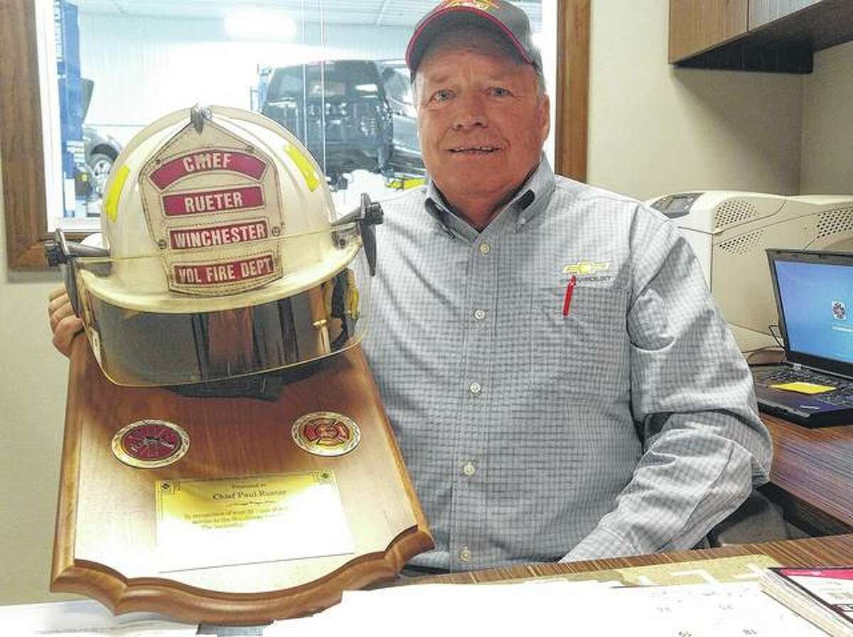 Outgoing Fire Chief Paul Rueter shows a plaque given to him by the Winchester City Council to commemorate his years of service.